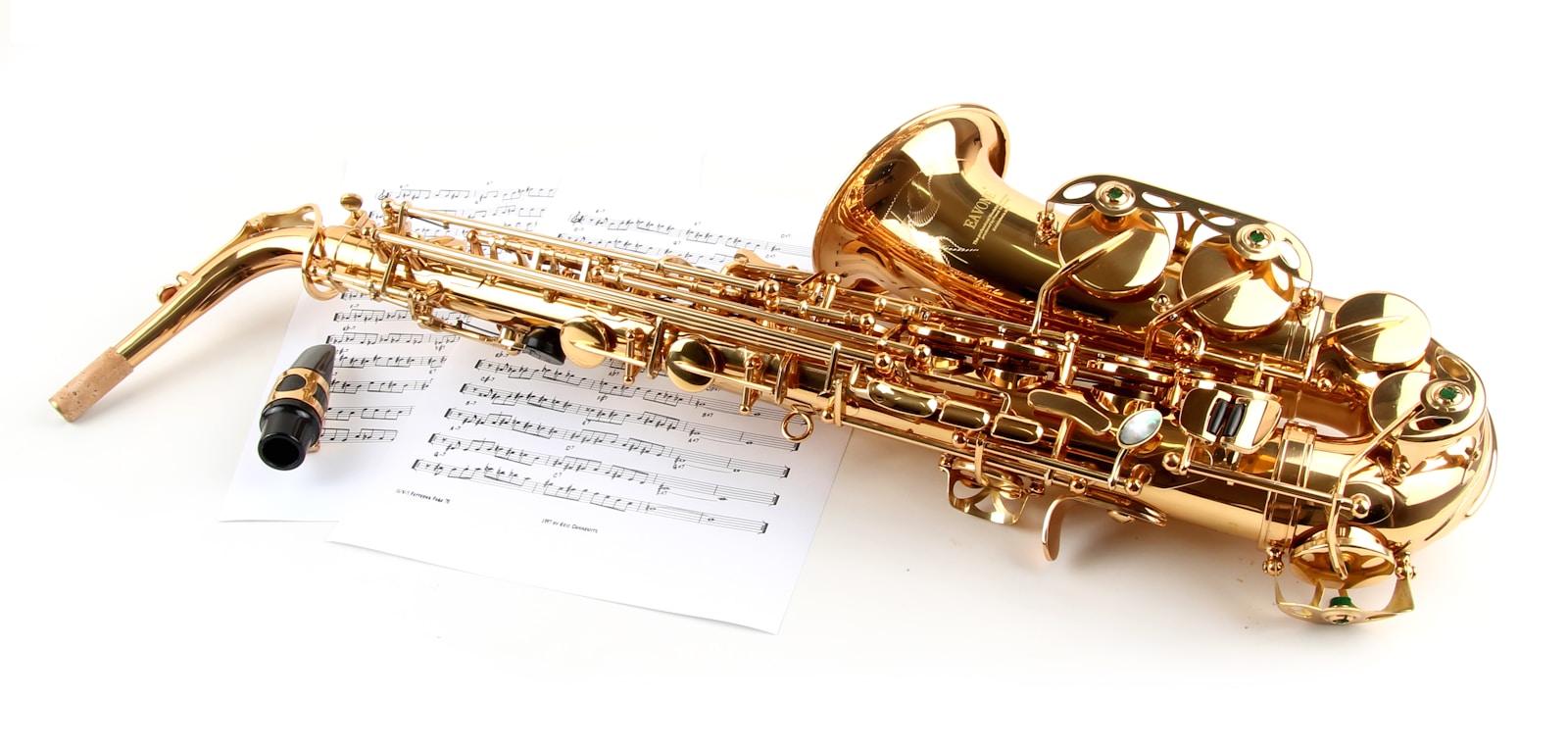 a golden saxophone sitting on top of a sheet of music
