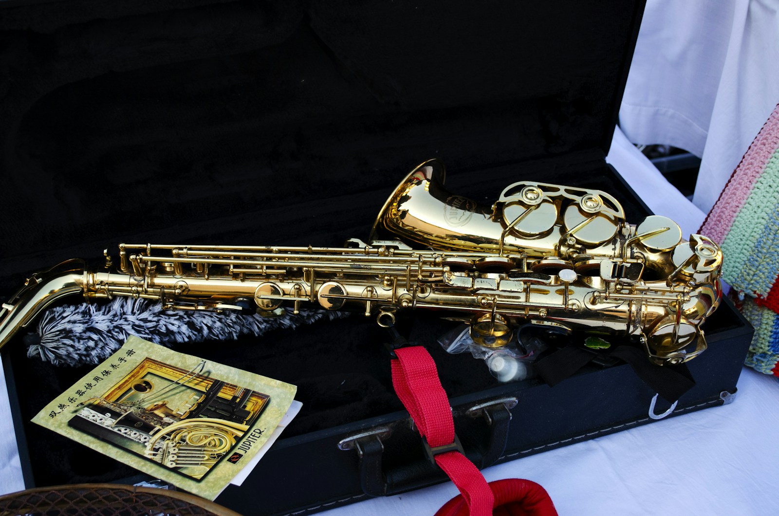 A shiny brass saxophone rests in its case.